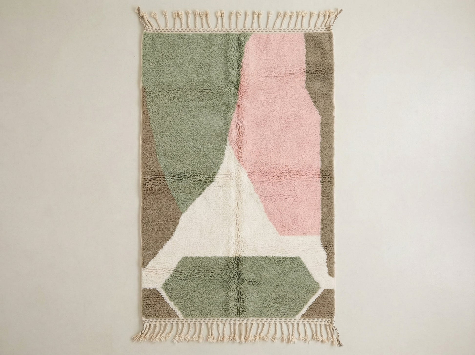 Custom made Beni Ourain Moroccan wool rug featuring geometric diamond patterns in soft sage green, powder pink, white, and earthy taupe with traditional fringe.