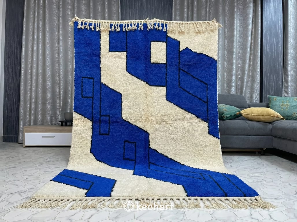 Detail shot of the high-pile wool texture and hand-knotted fringe of a bespoke Azur blue and cream Moroccan rug in a minimalist hallway.