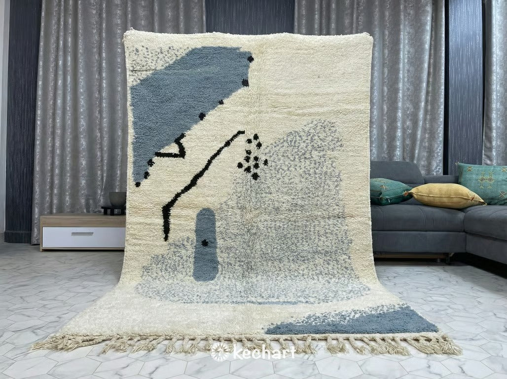 Close-up view of the high pile wool texture and hand-knotted craftsmanship of a custom Beni Ourain rug, showing the natural variations in the cream and dusty blue yarn.