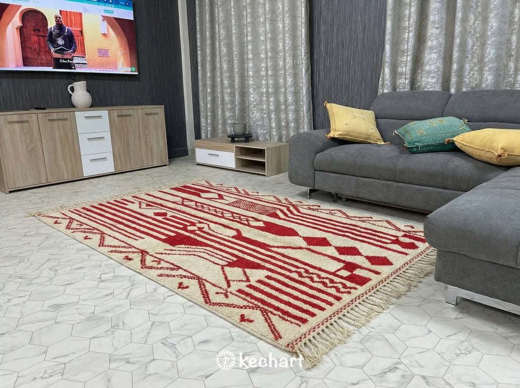 Modern bohemian living room featuring a large custom cream and red Beni Ourain area rug anchoring a neutral sofa and wood coffee table.