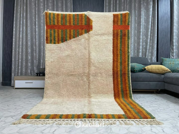 Large custom Moroccan wool rug with subtle geometric diamond pattern adding texture and warmth to a minimalist, Japandi-style living space with concrete floors.