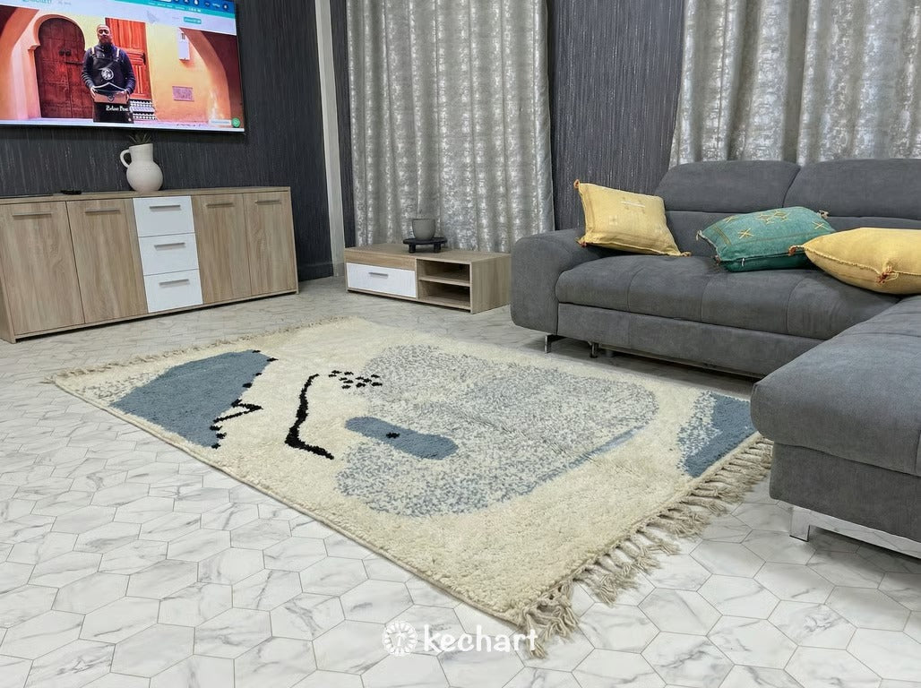 Close-up view of the high pile wool texture and hand-knotted craftsmanship of a custom Beni Ourain rug, showing the natural variations in the cream and dusty blue yarn.