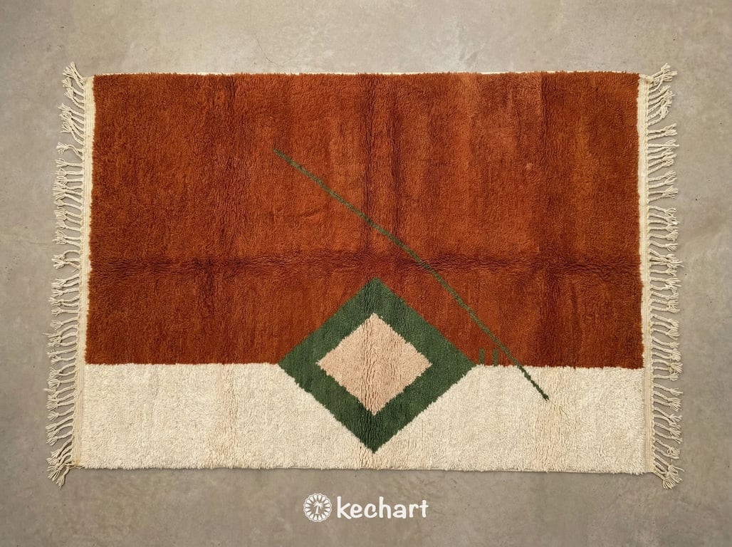 Custom made Beni Ourain Moroccan wool rug showing plush shaggy texture and geometric diamond pattern in earth tones of rust, dust storm, and pesto on beige background with traditional fringe.