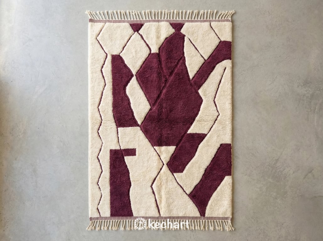 Custom made Beni Ourain Moroccan wool rug featuring plush cream pile and geometric diamond patterns in rich Bordeaux red dye. Handwoven Berber textile with traditional fringe.
