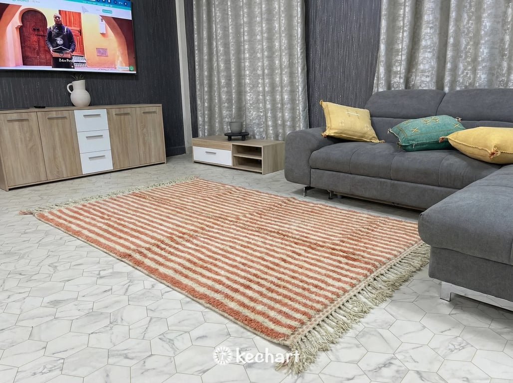 Plush shaggy Moroccan wool rug in a bohemian bedroom setting, partially under a queen-sized bed with soft textures, highlighting the warm salmon diamond motifs against the cream base.