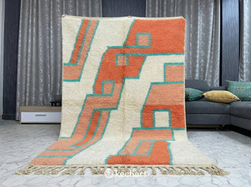 Artisan crafted Moroccan wool rug with a colorful diamond motif shown in an eclectic bedroom setting.