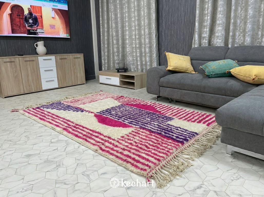 Large custom Moroccan area rug in a modern bohemian living room anchoring a white linen sofa and wooden coffee table