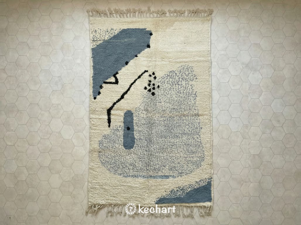 Custom Beni Ourain Moroccan wool rug with plush cream shag pile and dusty blue grey geometric diamond patterns, showing traditional fringe detail.