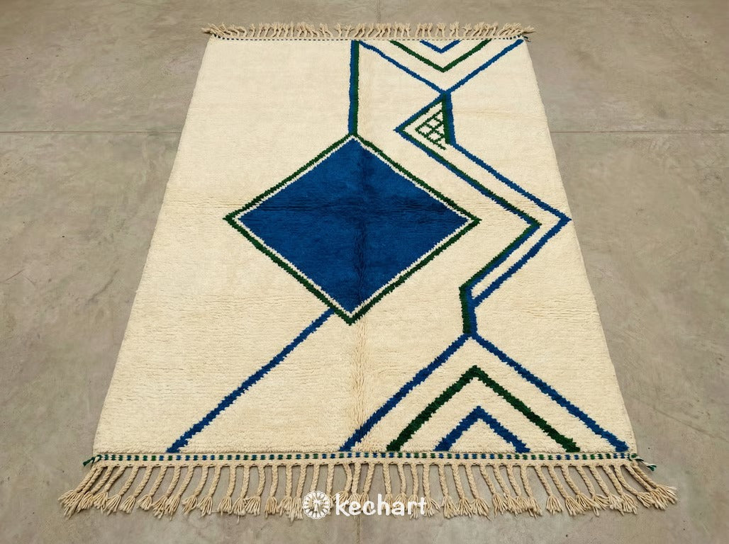 Custom made Beni Ourain Moroccan wool rug featuring geometric diamond pattern in Moroccan blue, fir green, and soft white. Plush shaggy texture with traditional fringe. Handwoven to order.