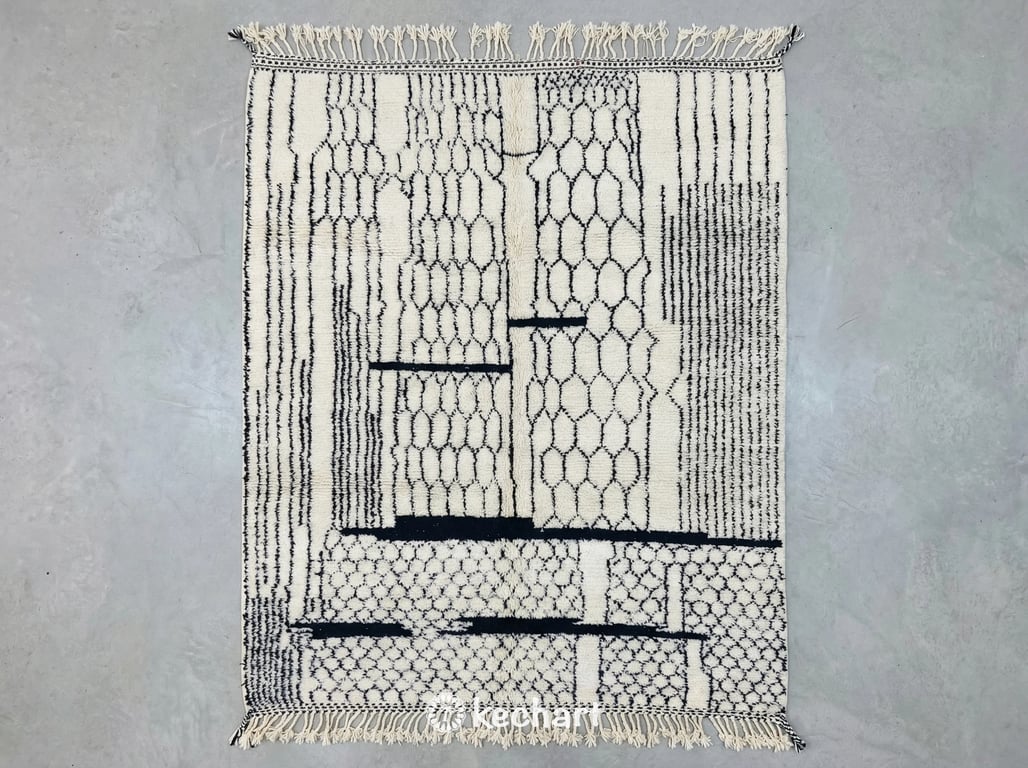 Custom made Beni Ourain Moroccan rug flat lay showing plush cream wool texture and charcoal geometric diamond pattern with traditional fringe detail.