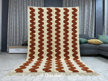 Handwoven Berber wool rug in custom size showing soft cream pile and rust geometric lattice pattern, adding warmth to a minimalist nursery or home office.