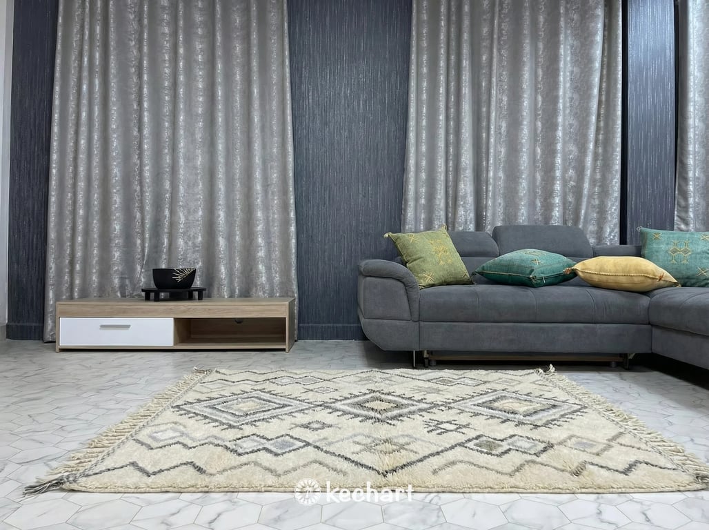 Cozy shaggy wool Berber rug in warm grey tones placed beside a large bed in a tranquil, bohemian style primary bedroom setting.
