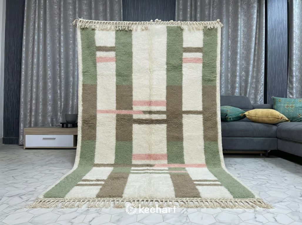 Close-up detail of the hand-knotted wool texture, traditional fringe, and the sage green and pink diamond motif of the custom Berber rug.