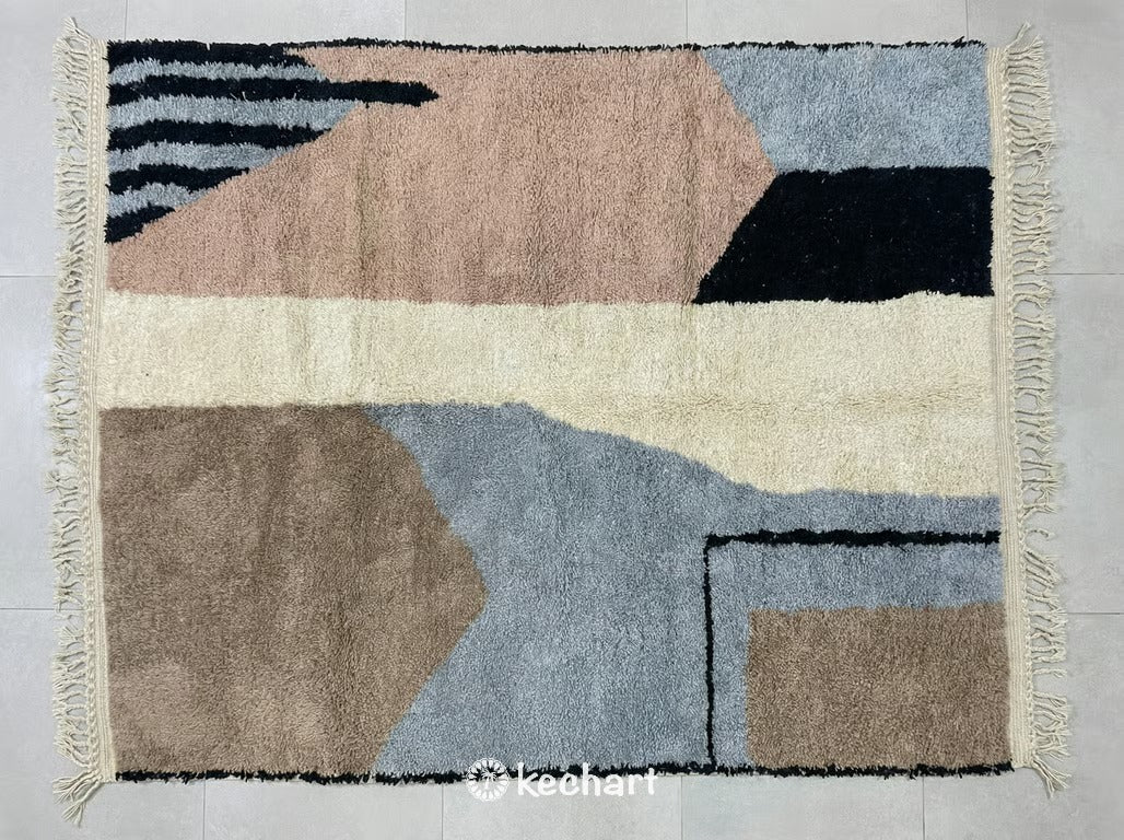 Custom made Beni Ourain Moroccan wool rug with plush shaggy texture. Sand colored base featuring geometric diamond patterns in sahara brown, dusty blue grey, and breen tones with traditional fringe.