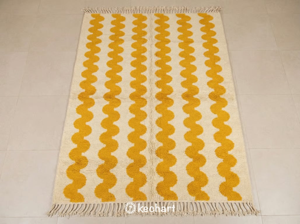 Close-up texture shot of custom Beni Ourain Moroccan rug showing plush cream wool pile and vibrant saffron geometric diamond patterns with traditional braided fringe.